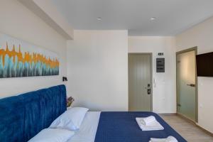 a bedroom with a bed with a blue head board at Syranna in Ermoupoli