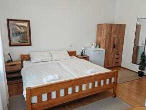 a bedroom with a large bed with white sheets at Apartments Vesna in Slunj