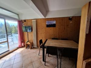 a dining room with a table and a large window at Casa Cris SoleAlto in Marilleva