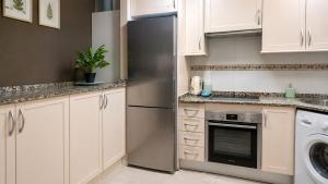 a kitchen with white cabinets and a stainless steel refrigerator at Casanova in Calpe