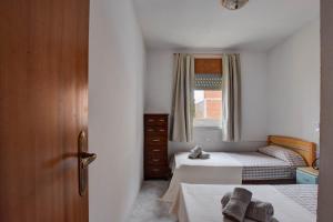 a small bedroom with two beds and a window at Casa Bon Matí in L'Ampolla