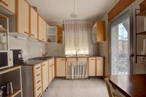 a kitchen with wooden cabinets and a sink and a window at Casa Bon Matí in L'Ampolla