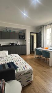 a bedroom with a bed and a kitchen with a table at Centro Storico Caruggi 2min Acquario Pellicceria Superior Loft Palazzo Rolli in Genoa +144 photos