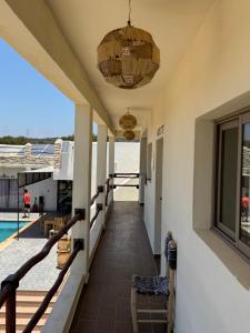 a hallway of a house with a pool and a chandelier at ,,,''' Sidi kaouki Tayoukhte Surf House with Pool ''' ,,, Surfing lessons, Horse Riding & Quad adventures ,,, Local experiences all in one place in Sidi Kaouki