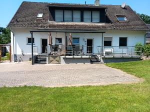 ein großes weißes Haus mit Terrasse und Rasen in der Unterkunft Ferienwohnung Berger in Greven