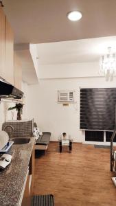 a kitchen and living room with a couch and a window at Mactan Cozy Hub Amani Grand in Lapu Lapu City