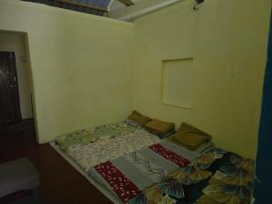 a small bed in a corner of a room at Pilankar Guest House in Ratnagiri