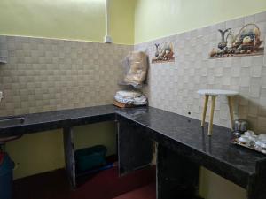a kitchen with a black counter top in a room at Pilankar Guest House in Ratnagiri