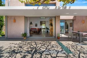 a house with a courtyard with a table and chairs at Mediterra Messinia in Kalamata