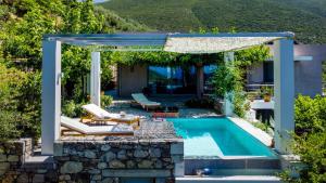 a pool with a pergola next to a house at Mediterra Messinia in Kalamata