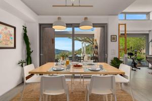 a dining room with a table and white chairs at Mediterra Messinia in Kalamata