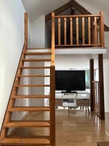 a loft bed with a tv in a living room at Maisonnette in Chambon-sur-Voueize