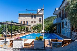 a pool in front of a building with chairs and a building at Apart & Spa Beganovic in Dobra Voda