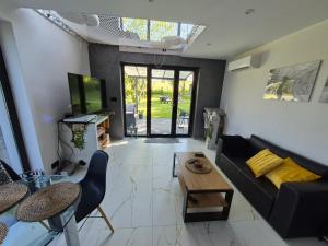a living room with a black couch and a table at Sauna-ForRest in Marynin