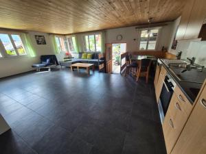 a kitchen and living room with a couch and a table at Chalet Sunnegg in Adelboden