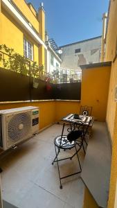 a balcony with a heater and a table and chairs at Centro Storico Caruggi 2min Acquario Pellicceria Superior Loft Palazzo Rolli in Genoa
