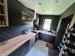 a kitchen with a wooden counter top and a sink at Sauna-ForRest in Marynin