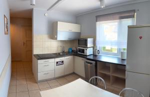 a kitchen with white cabinets and a black counter top at Pokoje gościnne Anna in Rewa