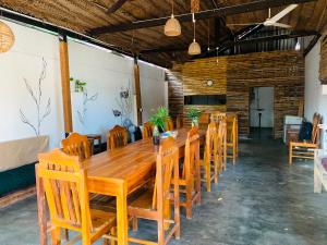 a long wooden table and chairs in a room at Arugam Bay Beach House in Pottuvil