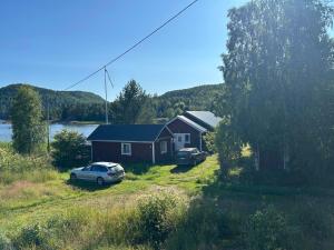 a house with two cars parked in front of it at Höga kusten Berghamn in Noraström +5 photos