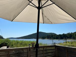 a large white umbrella sitting on a fence next to a lake at Höga kusten Berghamn in Noraström