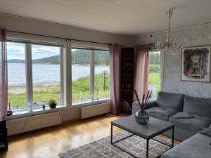 a living room with a couch and large windows at Höga kusten Berghamn in Noraström