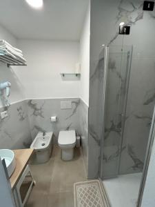 a bathroom with a shower and a toilet and a sink at Hotel Mirage in Lido di Jesolo