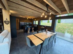 a dining room with a wooden table and chairs at Chalet du paradis in La Bresse