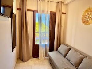 a living room with a couch and a window at Aetherion in Agios Ioannis Pelio