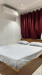 a bedroom with a bed with a red curtain at Universal Inn in Chennai