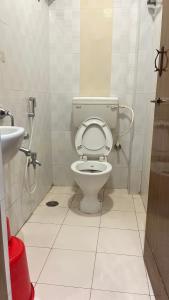 a bathroom with a toilet and a sink at Universal Inn in Chennai
