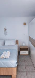 a bedroom with a bed with two towels on it at Green Boat House in Skala