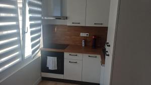 a small kitchen with white cabinets and a window at Appartement lena in Boulogne-sur-Mer +2 photos