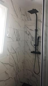 a bathroom with a shower with a marble wall at Appartement lena in Boulogne-sur-Mer
