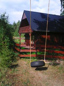 a tire swing in front of a cabin at Domek Rokitki in Rokity