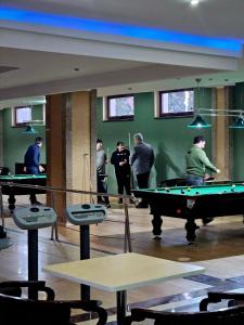 a group of people standing around a pool table at Deny Inn Harmony in Zărneşti
