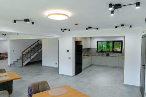 a large room with a kitchen and a staircase at Mira Montis in Borşa