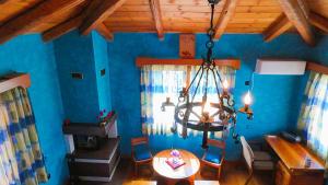 a dining room with blue walls and a chandelier at Villa Evmaria in Áyios Konstandínos