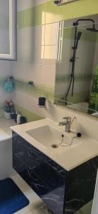 a bathroom with a sink and a mirror at Coquet ac accès autonome in El Aouina Station