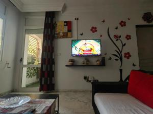 a living room with a tv on a wall at Coquet ac accès autonome in El Aouina Station