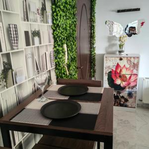 a dining table with two black plates and a wine glass at Coquet ac accès autonome in El Aouina Station +5 photos