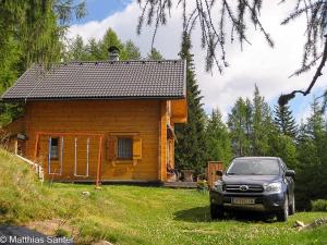 a car parked in front of a small house at Almhütte Tschiernock in Seeboden