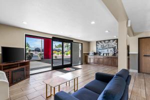 a living room with a blue couch and a tv at Super 8 by Wyndham Mesa Gilbert in Mesa +18 photos
