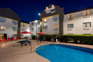a hotel with a swimming pool in front of a building at Super 8 by Wyndham Mesa Gilbert in Mesa