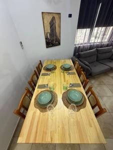 a wooden table with plates and wine glasses on it at Tirana Skyline Apartment in Tirana +6 photos