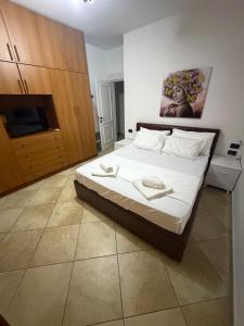 a bedroom with a bed with white sheets on it at Tirana Skyline Apartment in Tirana