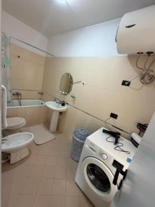 a bathroom with a washing machine and a toilet at Tirana Skyline Apartment in Tirana
