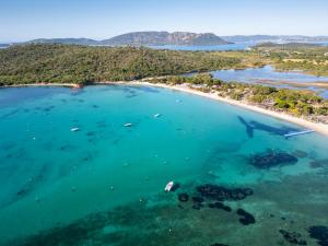 an aerial view of a beach with a boat in the water at Hôtel Spa & Restaurant - Son de Mar in Porto-Vecchio