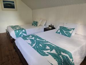 two beds with green and white blankets in a room at Ti kaz Annah in Le Tampon