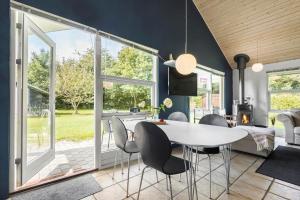 a dining room with a white table and chairs at 8843-Glesborg-Lyngtoften-34 in Glesborg